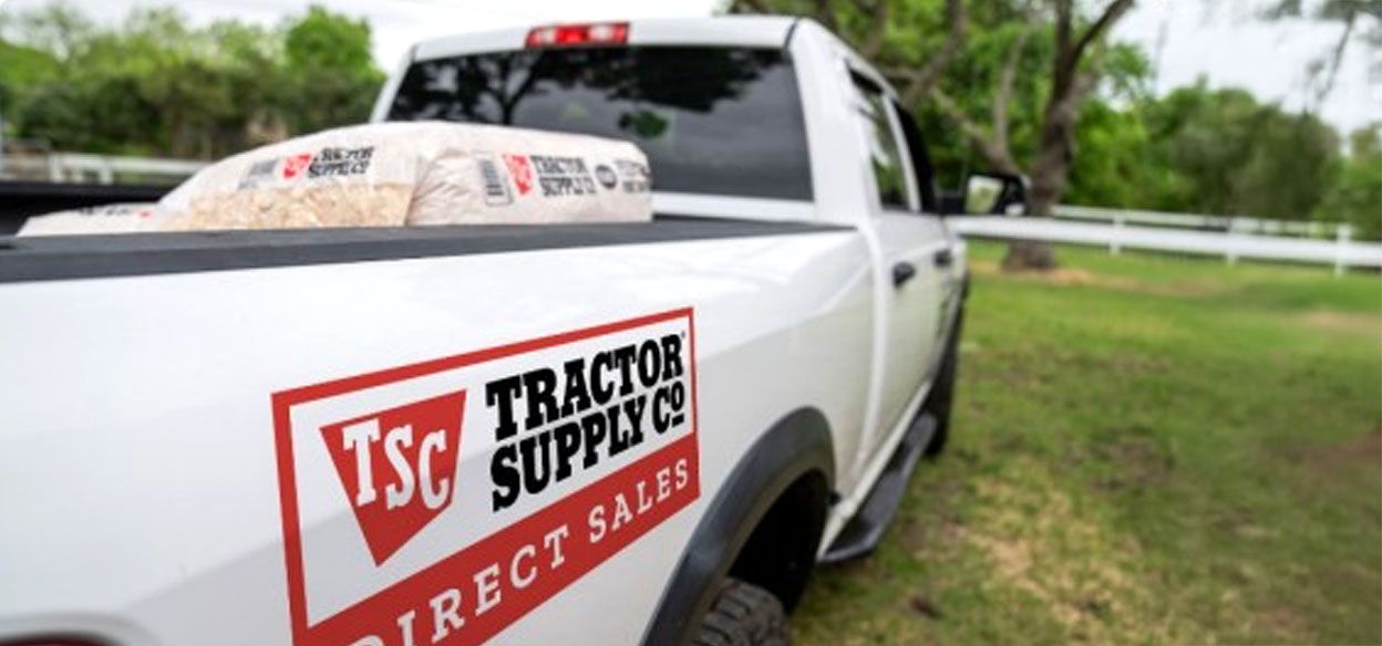 A Tractor Supply delivery truck parked on a property.