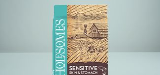 A bag of Wholesomes®Sensitive Skin &Stomach pet food featuring a turquoise vertical brand panel and a rustic farm illustration with a barn,windmill,fields,and dogs;the product name "Sensitive Skin &Stomach"appears on a dark label at the bottom right.