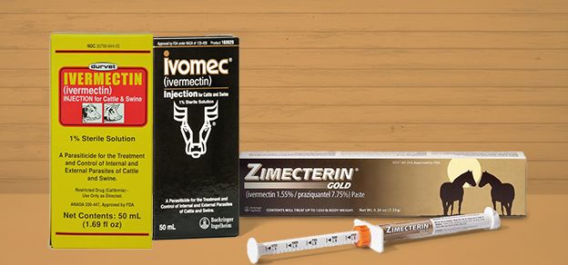 Three types of livestock dewormers displayed against a wooden backdrop:Durvet Ivermectin for cattle &swine,Ivomec injectable solution featuring a cattle icon,and Zimecterin Gold paste for horses with syringe applicator in front of the packaging.